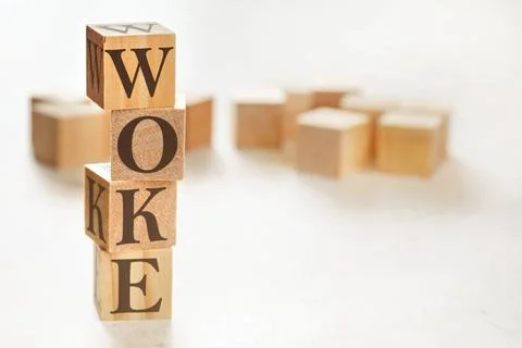 Four wooden cubes arranged in stack with word WOKE (stands for Wisdom Oppo... 스톡 사진