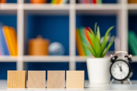 Four wooden cubes with copy space and alarm clock Stock Photos