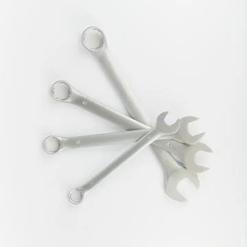 Four wrenches of different sizes lay fanning out against a light background, Stock Photos