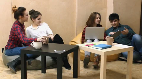 Four yang people communicate with each other, sitting on the chairs in  lounge Stock Footage 63364657