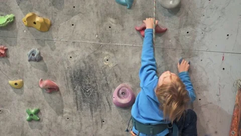 Four year old boy climbs the climbing wall in the hall. Video stock 223488499