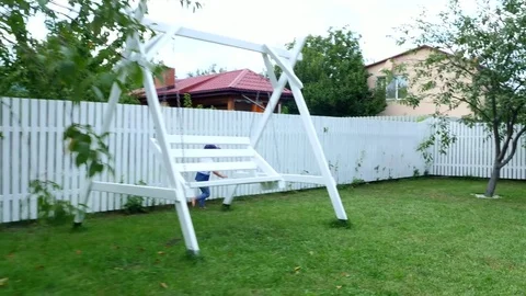 A four-year-old boy joggling barefoot on a green lawn, on the grass, in the Stock Footage 80442570
