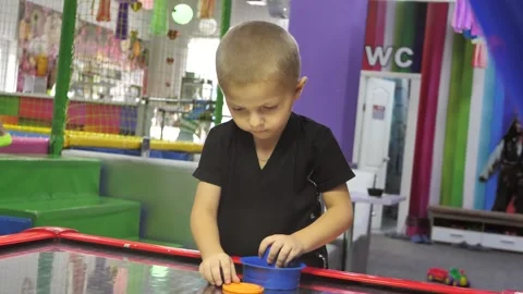 Four year old boy likes to play air hockey on the playground for fun. Stock Footage 280151746