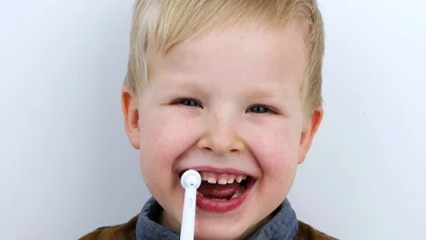 Four year old child brushes his teeth with an electric brush. The boy on a white Stock-Footage 124946908