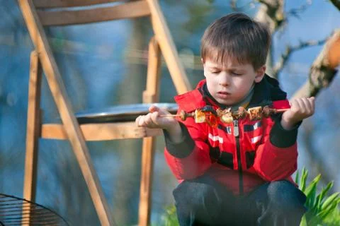 Four years old boy eats grilled vegetables Stock Photos