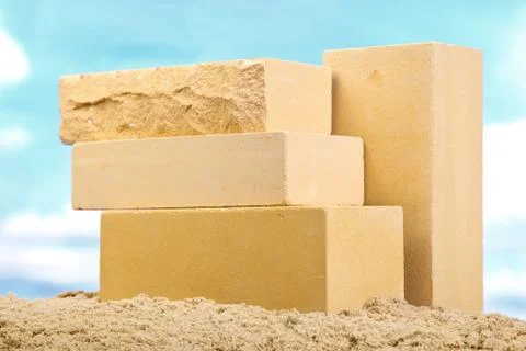 Four yellow ceramic bricks on the sand at the blue sky background Stock Photos