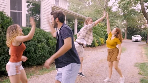 Four young adults high five and get into an SUV getting ready for a road trip Stock Footage 120639507