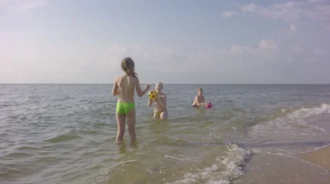 Four young children playing on the beach balls. 库存影片 64669069