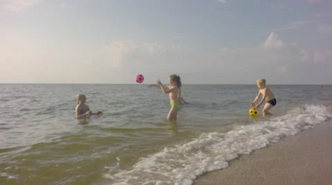Four young children playing on the beach balls. Video stock 64669095