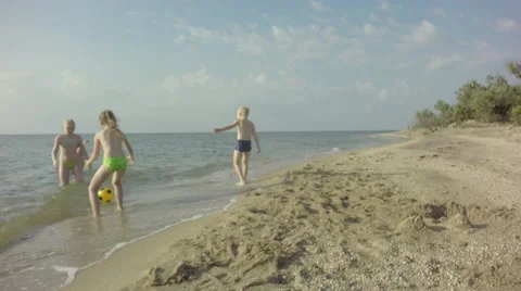 Four young children playing on the beach balls. 库存影片 64669115