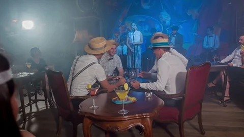 Four young men wearing straw hats sitting in front of a stage Stock Footage 112201415