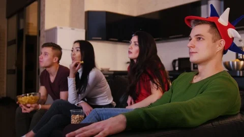 Four young people watching TV and flipping television channels Stock Footage 101542004