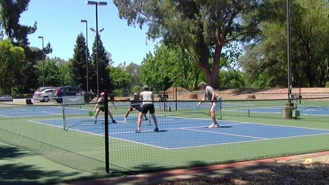 Foursome of couples playing Pickleball in daytime outside in Northern California Stock Footage 145767933