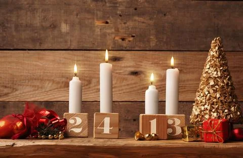Fourth Advent candle burning on a rustic wooden table Stock Photos