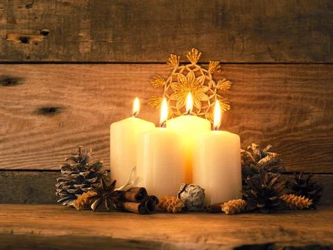 Fourth Advent candle burning on a rustic wooden table Stock Photos