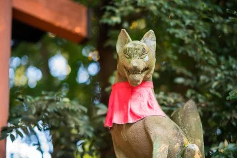 Fox the messenger of god statue front of red torii gates in Fushimi Inari temple Stock Photos