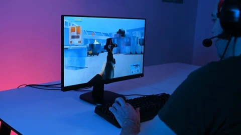FPS video game on computer played by man with headset sitting in front of screen Stock Footage 100724231