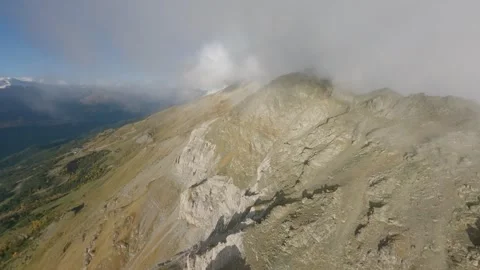 FPV aerial pass along rugged alpine ridge in drifting mist Stock Footage 337096117