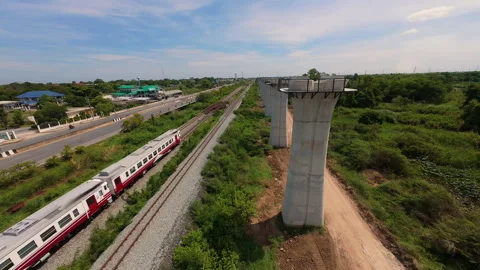 FPV Aerial Shot of Train Passing Elevated Railway Construction in Rural Area Vidéo 336805200