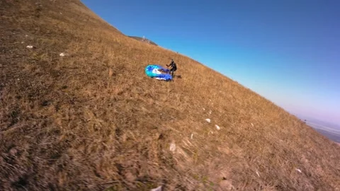 FPV aerial view of flying next to a paraglider after landing in a mountainous Video stock 280212528