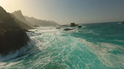 FPV aerial view of turquoise waves crashing on rocks, Spain. Stock Footage 345070900