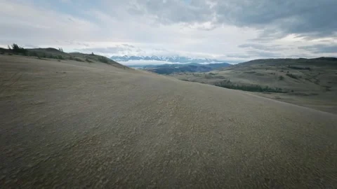 The FPV copter flies fast at low altitude over the hills. Cloudy evening weather Video stock 278368251