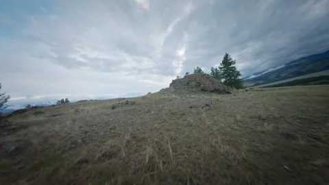 The FPV copter flies fast at low altitude over the hills. Cloudy evening weather Stock Footage 278368319