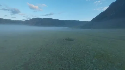 The FPV copter flies low to the ground. Shooting early in the morning at dawn in Video stock 278368849