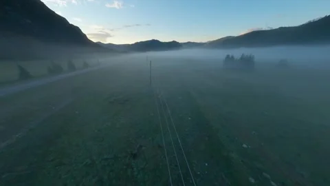 The FPV copter flies low to the ground. Shooting early in the morning at dawn in Stock Footage 278368955