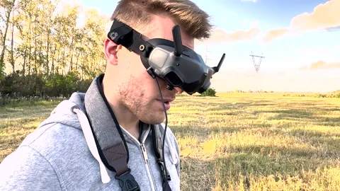 FPV copter pilot controls the drone using a remote control and wearing glasses	 Stock Footage 285149609