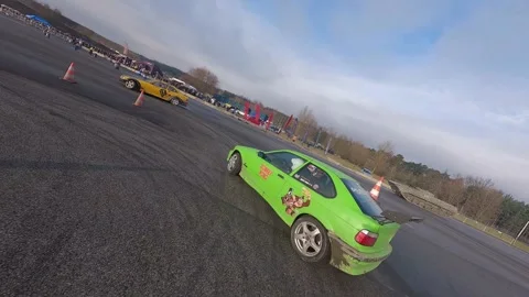 FPV Drift Duo: Sunlit Green &amp; Yellow BMWs on Milovice Track Stock Footage 324922559