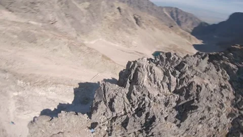 FPV drone aggresive flying around rocks and drone pilot in high mountains Stock Footage 169280533