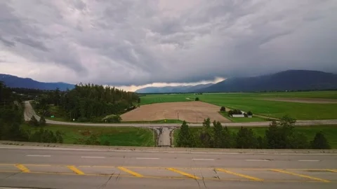 FPV drone ascending over road tunnel revealing agricultural valley and dramatic Vídeo Stock 337741517