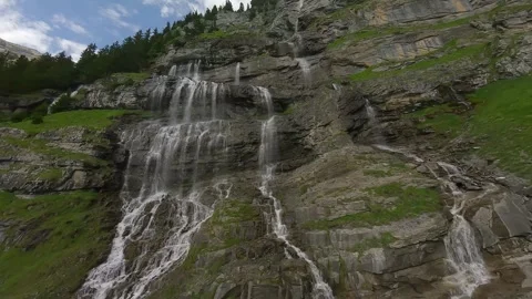 FPV Drone Ascent Along Alpine Waterfall on Rocky Mountain Slope 스톡 동영상 312410050