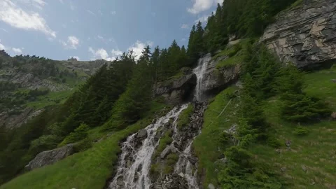 FPV Drone Ascent and Dive Along Alpine Waterfall Stock Footage 312410143