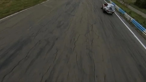 FPV drone chasing drift car in competition. Slow motion shot. 스톡 동영상 169414756