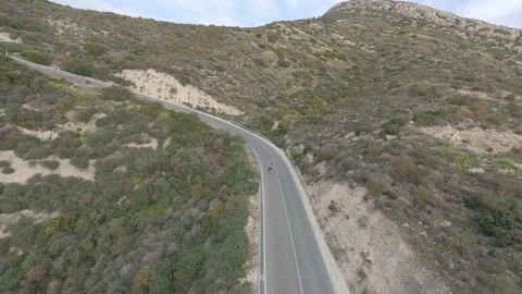 Fpv drone chasing motorbike driven by redhead woman on road Stock Footage 237024878