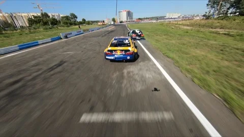 FPV drone chasing two drift cars in competition. Vídeos de archivo 169410865