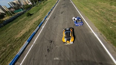 FPV drone chasing two drift cars in competition. Slow motion shot. Vídeos de archivo 169411036