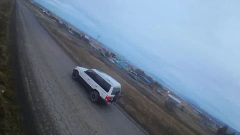 FPV Drone Chasing a White SUV Along a Dusty Patagonian Road, Puerto Natales Stock Footage 340283223