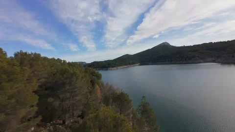FPV drone cinematic flight along Bimont lake shoreline in Provence Stock Footage 335371402