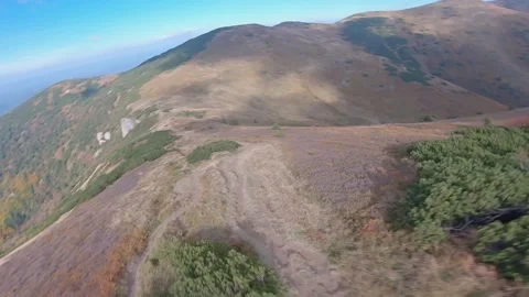 FPV drone cinematic flying close to ground at Fall in nice green mountains Stock Footage 169280611