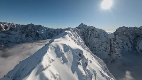 FPV Drone Cloud Surfing Over Snowy Mountain Peaks Alps, 4K Stock Footage 323465490