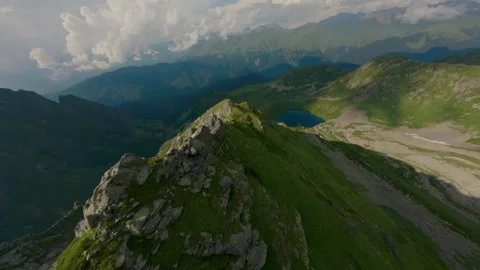 FPV drone dive mountain range to blue lake in canyon Stock Footage 330076136