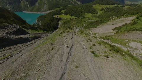 FPV Drone Dive from Rocky Alpine Peak to Forested Valley Stock Footage 312827590