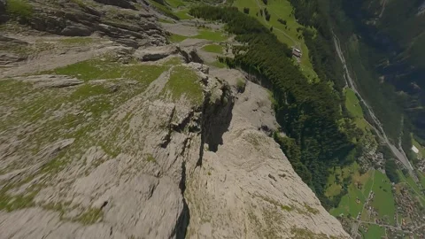 FPV Drone Dive From Rocky Summit to Forested Slopes Stock Footage 312956925