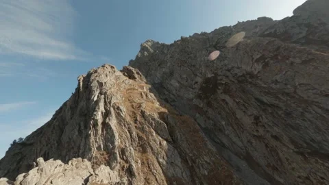 FPV drone dive shooting close rocky mountain slopes and cliff in sunny valley Stock Footage 146741551