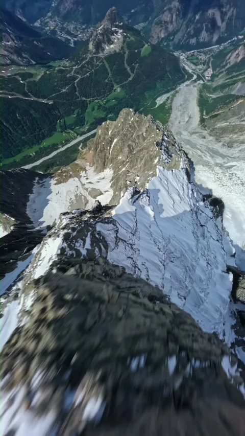 Fpv drone dive steep snow mountain ridge peak alpine valley high speed flight Stock Footage 340976372