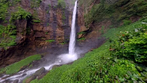 FPV drone dive through scenic waterfall in lush jungle East Java, Indonesia Vídeos de archivo 317504484