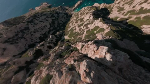 FPV drone diving down coastal cliff towards hidden cove in southern France Stock Footage 330987952